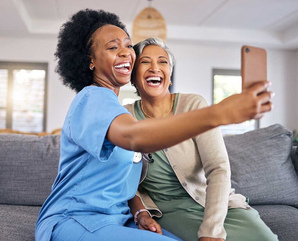 A caregiver and an older adult reviewing a care plan together at a bright living room table.